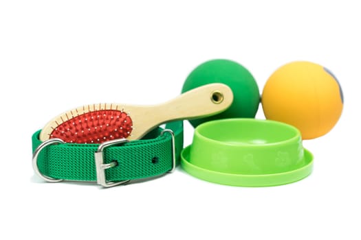 Pet accessories concept.  Bowls, Rubber toy, Collars and brush on isolated white background.