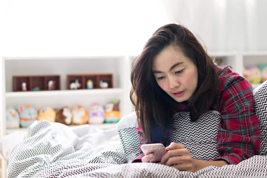 Woman using smartphone for social network at bedroom.  Media and technology concept.
