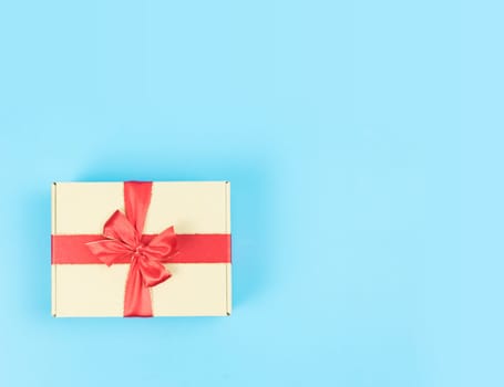 Gift box with red ribbon on color background. Object for Christmas day or Birthday present.