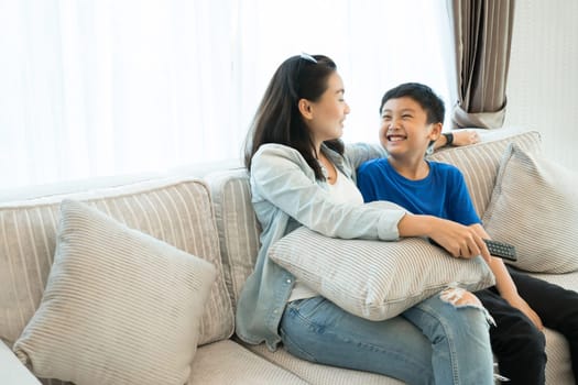 Happy family time. Mother and son relaxing in living room at home.