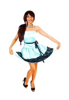 A gorgeous young woman dancing in a turquoise dress and high heels in the.studio, smiling, holding her dress up, isolated for white background.