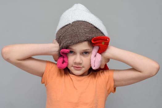 The girl put on a lot of things on her head so as not to hear loud sounds