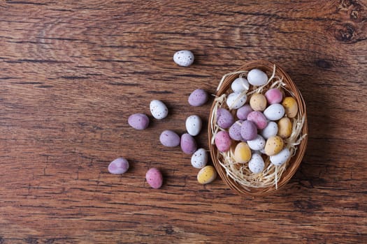 Colorful small Easter eggs on wooden table with copy space