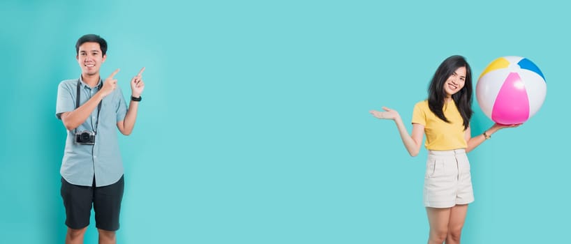 Happy Asian young beautiful woman handsome man couple in summer in holiday travel beach accessories ball and camera isolated on blue background with copy space for text