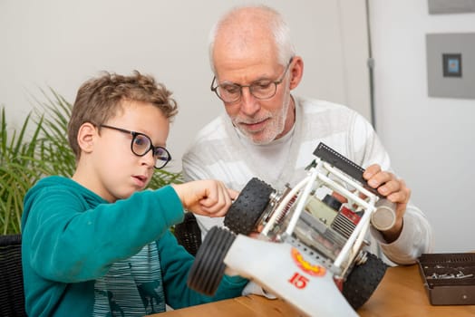 grandpa and son little boy repairing a model radio-controlled car