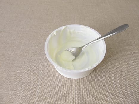 Empty plastic mug with remains of yogurt and a spoon