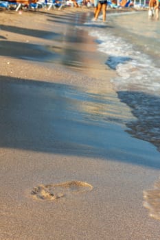 Greece, Rhodos - footprints on sand beach along the edge of sea. Kolympia