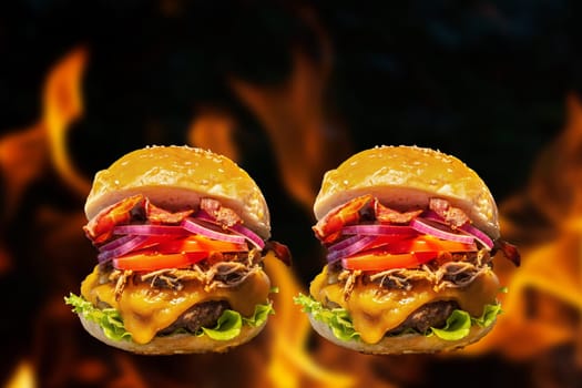 Close-up of home made burgers with fire flames and black background