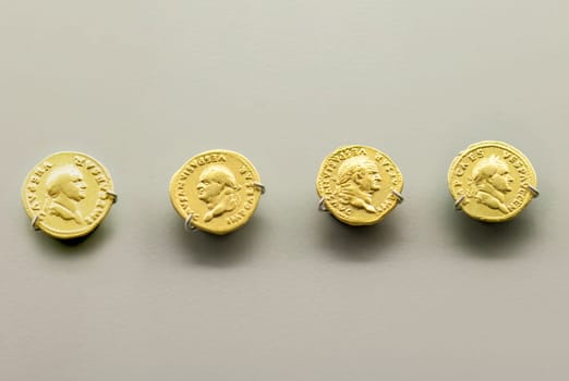 Merida, Spain - August 25th, 2018: Gold Roman Imperial coins bearing the bust of Emperor Vespasian. National Museum of Roman Art in Merida, Spain