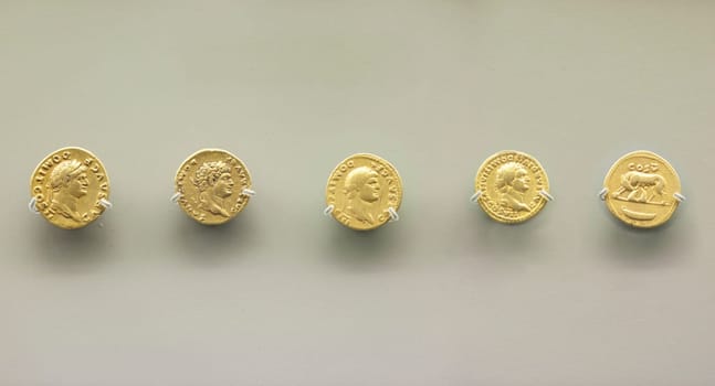 Merida, Spain - August 25th, 2018: Domitian Roman emperor gold coins. National Museum of Roman Art in Merida, Spain. Selective focus