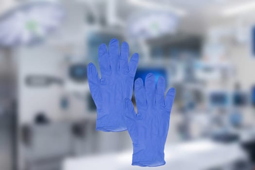 Coronavirus protective measures. Close-up of a pair of blue medical doctor gloves or surgical gloves on a blurred background of a modern hospital interrior. Blue rubber gloves for cleaning work.