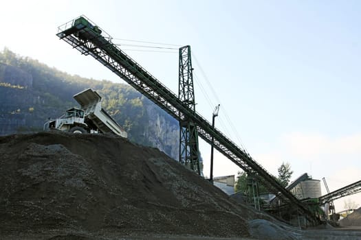 A gravel pit with tools and trucks in the mountains