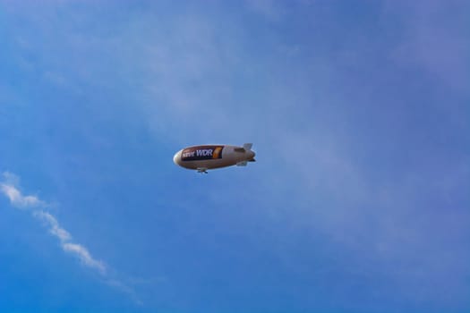 HEILIGENHAUS, NRW, GERMANY - SEPTEMBER 04, 2017:.Heiligenhaus, Nrw, Germany - September 04, 2017:.Zeppelin or even airship called in front of blue sky with advertising of the German radio station WDR 4.