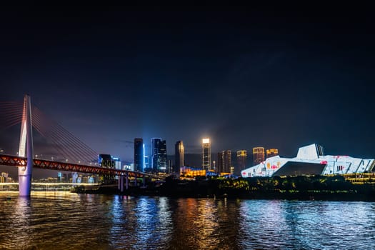 Chongqing, China -  August 2019 : Illuminated DongShuiMen road bridge over and across mighty Yangtze river in Chongqing town at dusk