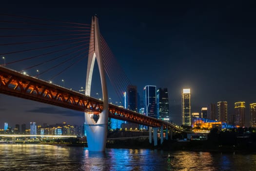 Chongqing, China -  August 2019 : Illuminated DongShuiMen road bridge over and across mighty Yangtze river in Chongqing town at dusk