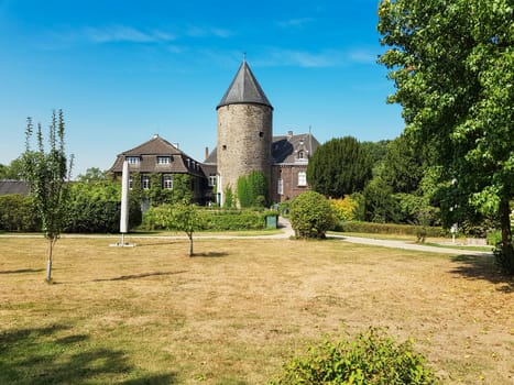 RATINGEN, NRW, GERMANY - AUGUST 22, 2018:.Ratingen, Nrw, Germany - August 22, 2018: .View of the mansion, from Linnep Castle. Old moated castle, side view to the castle on a sunny day.