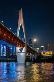 Chongqing, China -  August 2019 : Illuminated DongShuiMen road bridge over and across mighty Yangtze river in Chongqing town at dusk