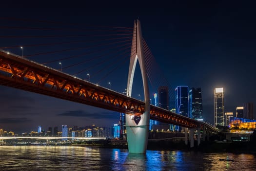 Chongqing, China -  August 2019 : Illuminated DongShuiMen road bridge over and across mighty Yangtze river in Chongqing town at dusk