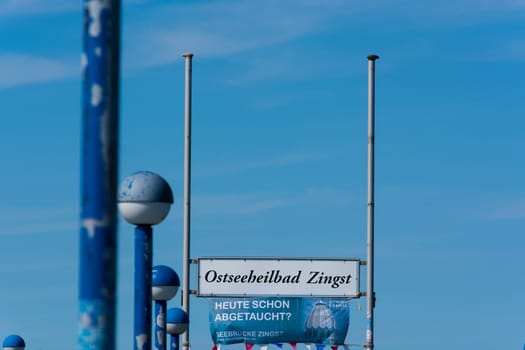 ZINGT GERMANY - JULY 29 2018: ..Zingt Germany - July 29 2018:.Poster and sign with Zingst inscription on the wooden pier in the Baltic Sea. Darss Peninsula Fischland-Darss-Zingst Germany.At the pier of Zingst on the Baltic Sea in Germany