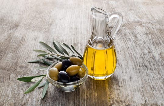 Olive oil and olive branch on the wooden table