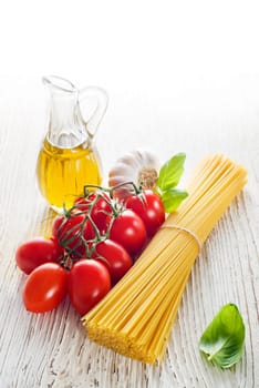 Spaghetti and tomatoes with oil on a vintage wooden table