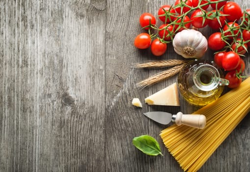 Spaghetti and tomatoes with parmesan cheese on a vintage wooden table