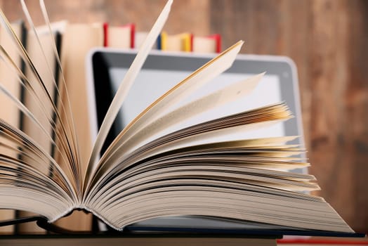 Composition with books and tablet computer on the table.