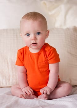 A young boy sits up in bed looking surprised