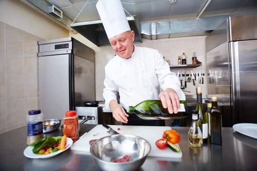 Chef adding oil at his dish