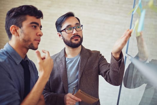 Two colleagues looking at their notes with tasks