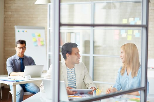 Confident businesswoman talking to male colleague in office