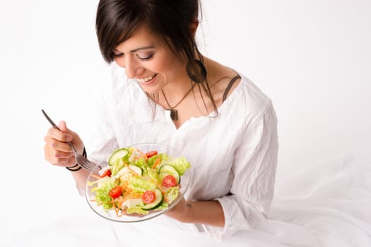 An attractive woman takes in the aroma of the salad she is about to consume