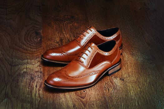 HK3AYD Brown men's shoes on wood background