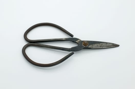 black vintage scissors on white textured background.