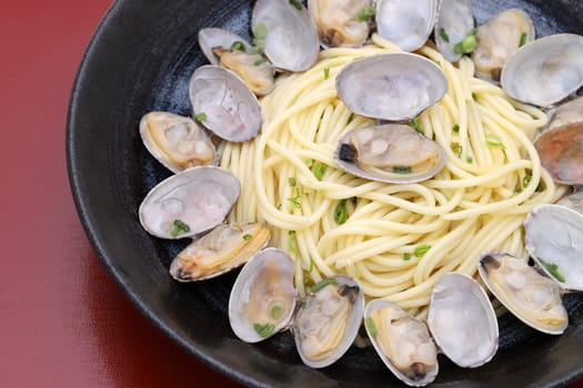 Close up of Vongole spaghetti in a dish on wooden table