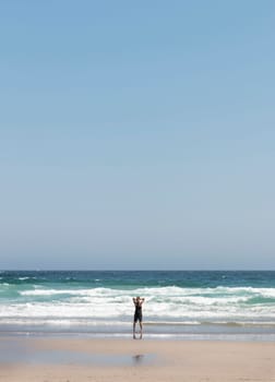 Relaxed blonde girl on her back contemplating the waves at the seashore