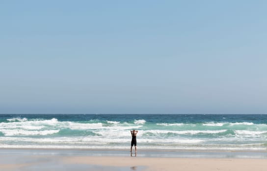 Relaxed blonde girl on her back contemplating the waves at the seashore