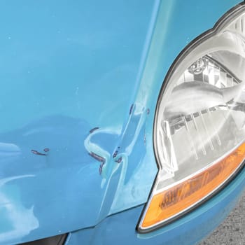 Damaged bodywork. Dents and scratch marks on a car's hood. Close-up.