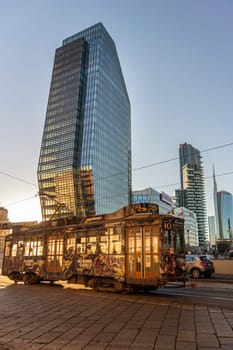 A tram travelling  in front of Modern buildings,  in the Business district in the city of Milan, Italy