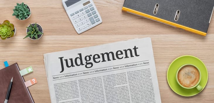A newspaper on a desk with the headline Judgement