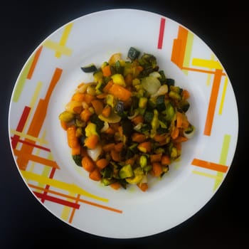 Cooked vegetables on decorated plate top view. Food background