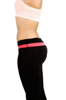 The middle section of a young woman standing in profile with a pink bra.and black pants, showing her body, isolated for white background.