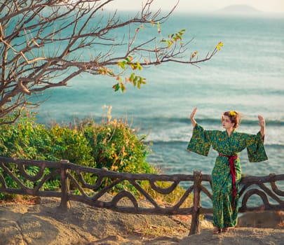 Portrait of a Japanese Geisha in kimono  at sunrise time near the sea