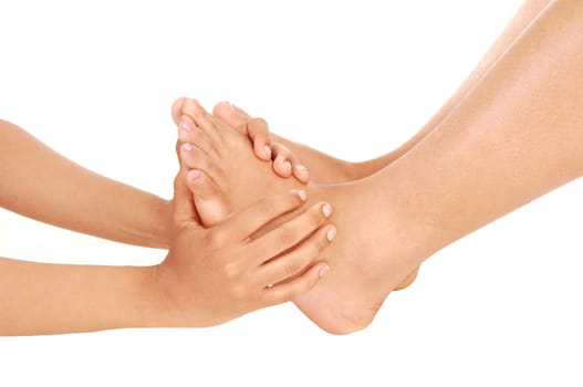 The feet of a young woman getting a massage from two hands in a .close up image isolated for white background.