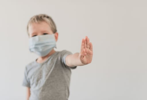Boy wearing facial disposable mask to avoid viral infection. Stop coronavirus