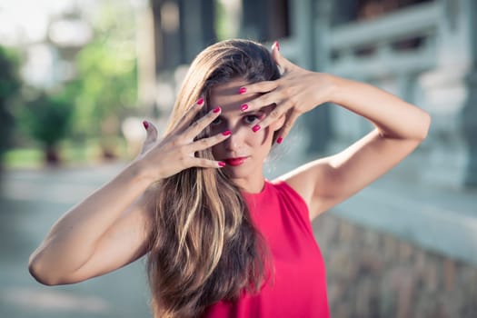 Fashion portrait of a beautiful woman in red dress outdoor