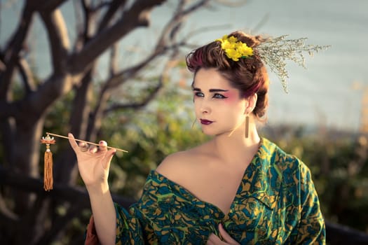 Portrait of a Japanese Geisha in kimono  at sunrise time near the sea
