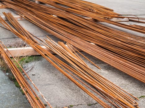 Diagonal oblique view of rebars stored on wooden beams at a construction site in Berlin.