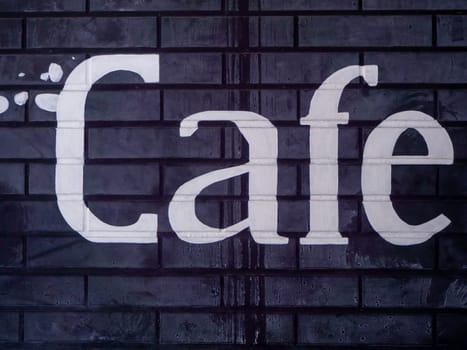 Black Brick Wall with Word Cafe in Worn White Paint