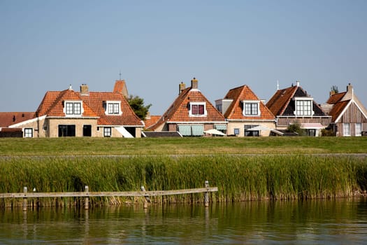 Historic houses behind te dike in Makkum, the Netherlands..